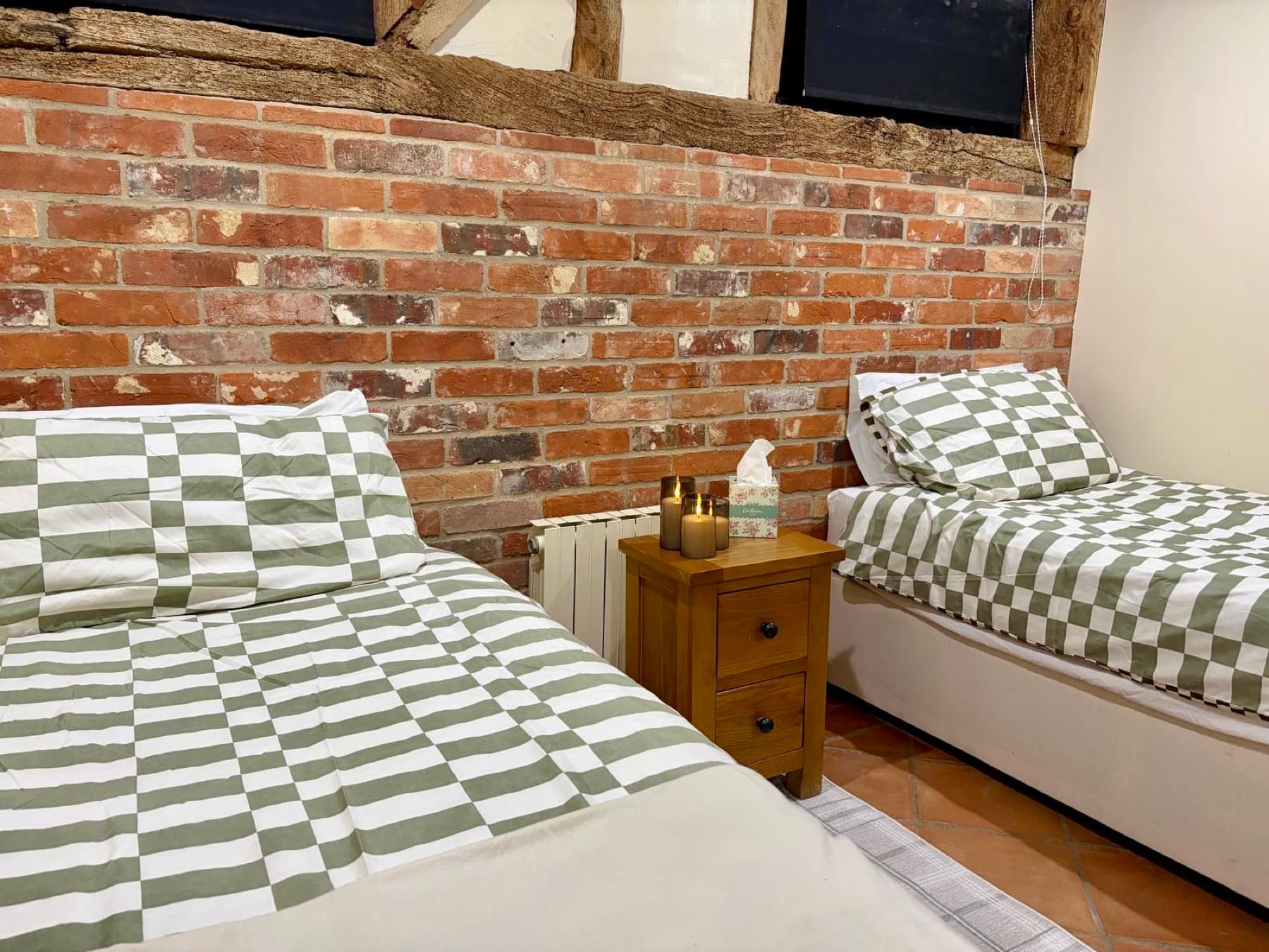 Twin bedroom with original oak beams and exposed brick
