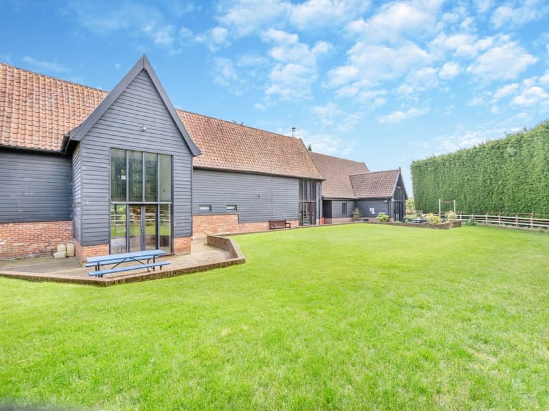 Clamp Farm Barn, black weatherboard barn conversion with glazed gables