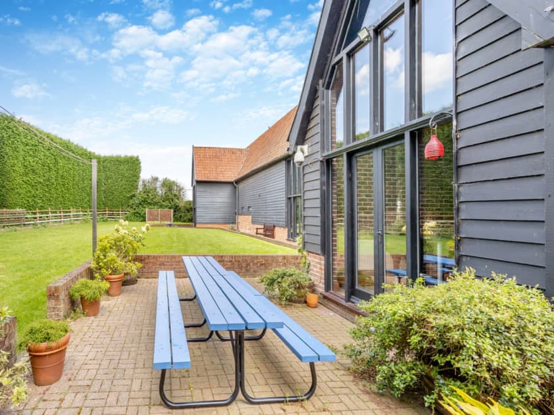 Patio and lawn beside the black weatherboard barn