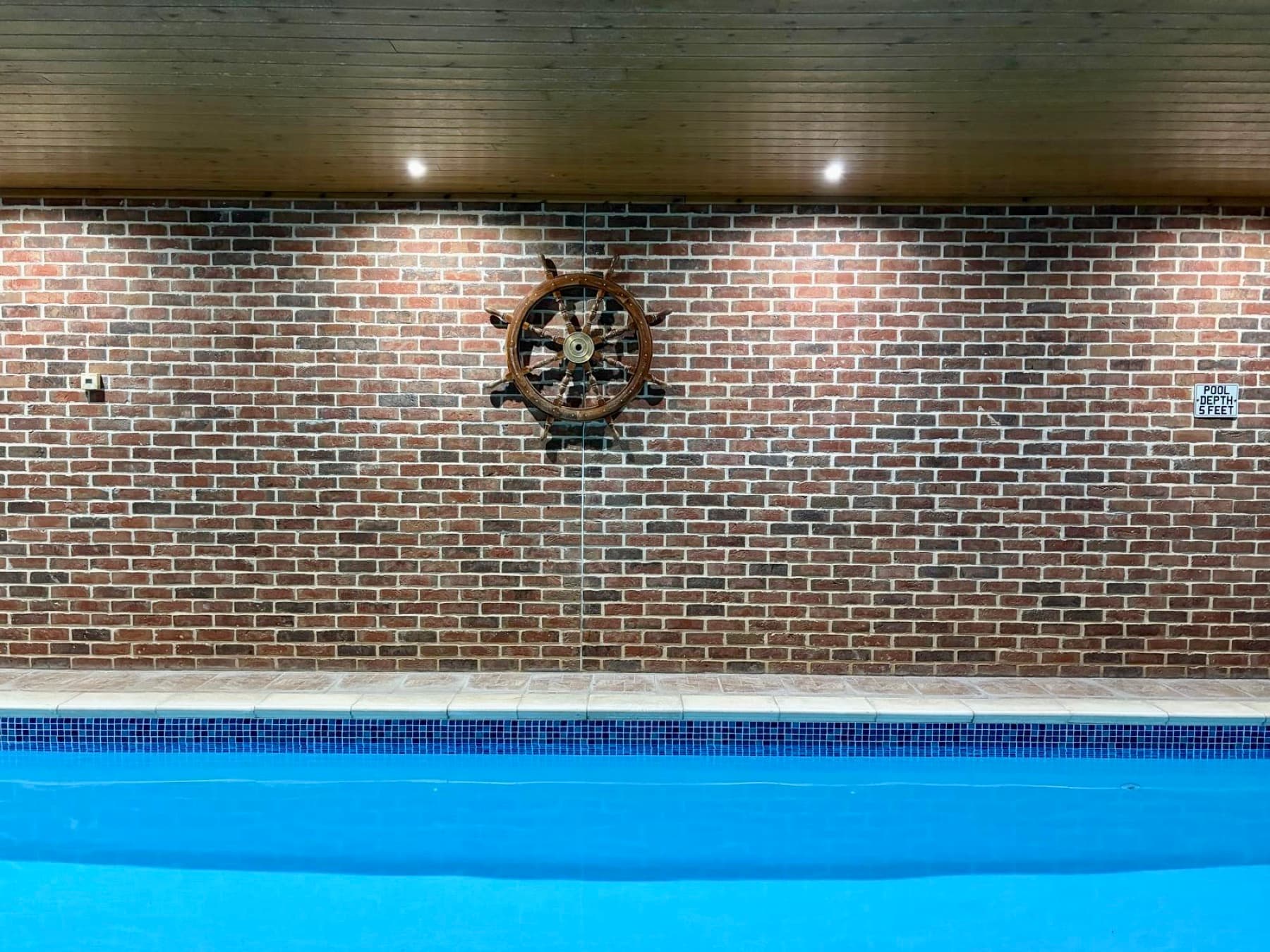 Pool wall with ship's wheel feature